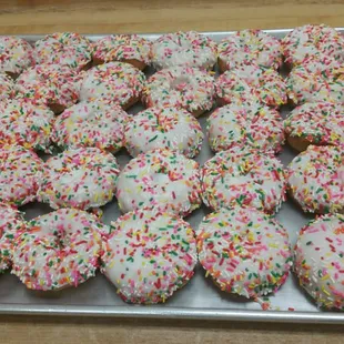 a tray of doughnuts with sprinkles