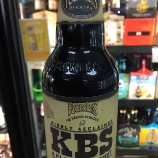 a hand holding a bottle of beer