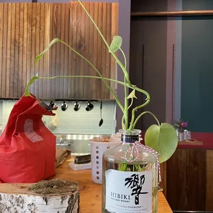 a wooden table with a bottle and a plant
