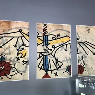 three paintings on a wall