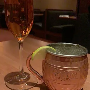 a glass of wine and a copper mug