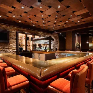 a bar with orange chairs