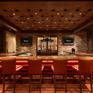a bar with red chairs