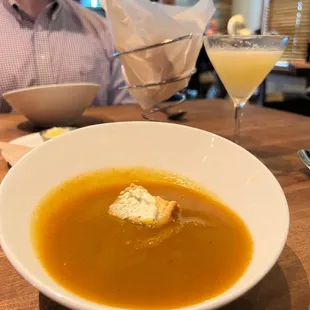 a bowl of soup and a glass of orange juice