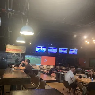 people sitting at tables in a bowling alley