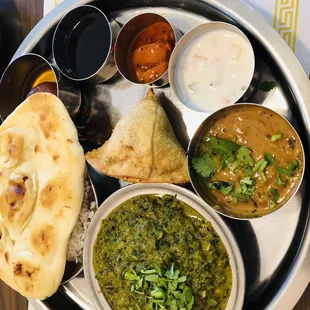 Lunch with Samosa appetizer, naan,-, Jeera rice, mango pickle, spinach and paneer curry, and lentils, Keer dessert