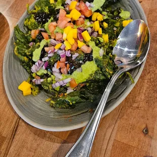a plate of salad with a spoon