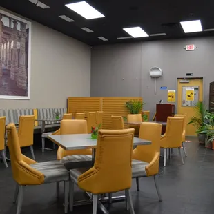 a dining area with yellow chairs and tables