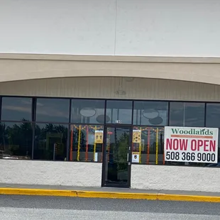 the front of a store with a sign for now open