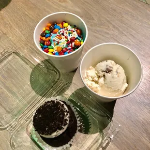 two cups of ice cream and a cupcake