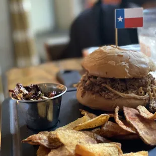 a pulled pork sandwich and chips