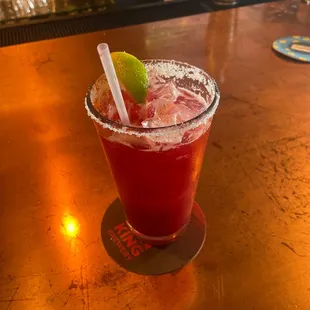 a drink with a lime garnish