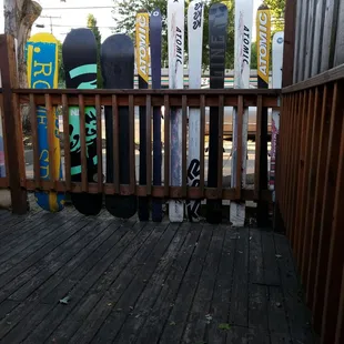 snowboards leaning against a fence