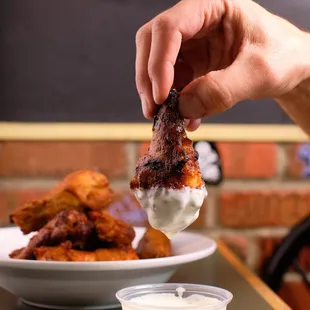 a hand dipping a piece of meat