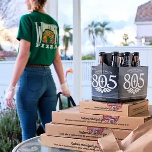 a woman carrying boxes of pizza