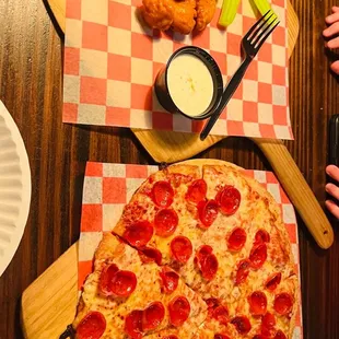 a pepperoni pizza and chicken wings