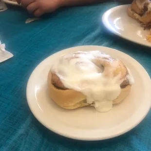 a cinnamon roll with icing on a plate