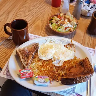 Toast, eggs, hash browns and a side salad in the background