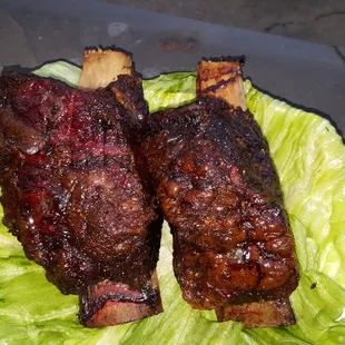 a plate of ribs and lettuce
