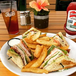 Turkey club sandwich with fries.