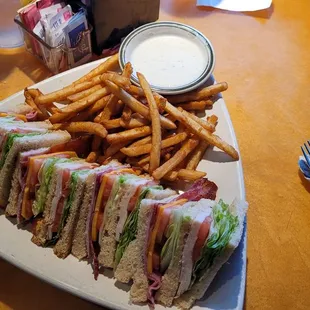 A Club Sandwich on Sourdough Toast with Beer Battered French fries..