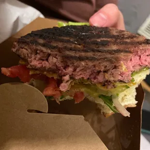 a hand holding a sandwich