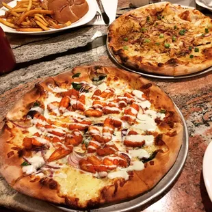 Buffalo chicken pizza up front and center, with a Jamaican Jerk and turkey burger in the background.