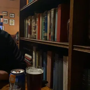 a man sitting at a table with a glass of beer