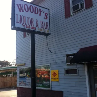 a sign for woody's liquor and bar