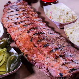 a rack of ribs, coleslaw, and pickles