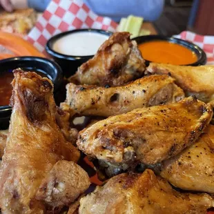 Dozen Chicken wings with buffalo, Thai garlic, and Ranch sauces on the side.