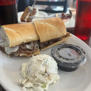 The &quot;French dip&quot; (a grilled sandwich). A roast beef based sandwich with cheese and Au Jus sided by a potato salad