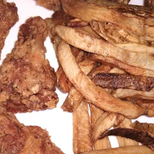 A close-up shot, wings small &amp; thin, fries limp &amp; oily.