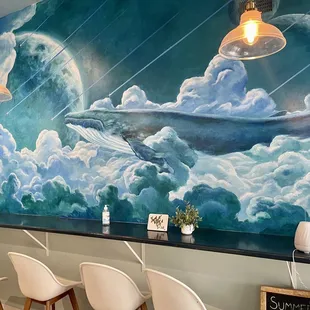 a mural of a whale in the sky
