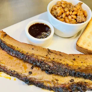 Sliced brisket and side of bbq beans