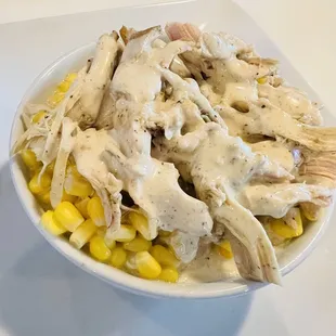 Chicken bowl: mashed potatoes, green chili corn and pulled chicken layered in a bowl topped with Alabama white sauce