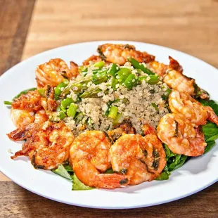 Marinated shrimp sautéed and served over quinoa, asparagus, green beans, spring onions, and lemon vinaigrette mixture on spinach and kale.