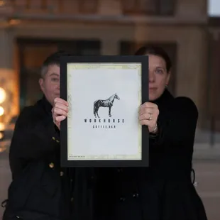 Owners holding their sign