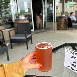 a person holding a glass of beer