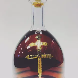 a glass bottle with a gold cross on it