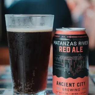 a can of red ale next to a glass of beer
