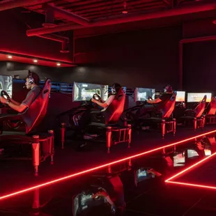 A row of drivers on our Esports Sims racing each other.