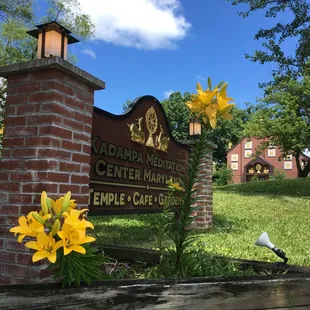 a brick sign and flowers