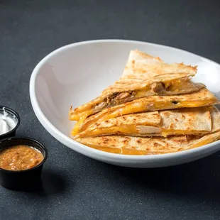 a bowl of quesadillas with dipping sauce