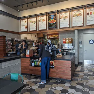 a man standing at the counter of a fast food restaurant
