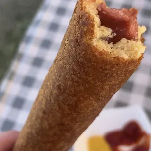 a hand holding a corndog