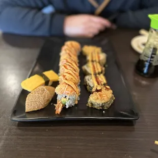 a man sitting at a table with a plate of sushi