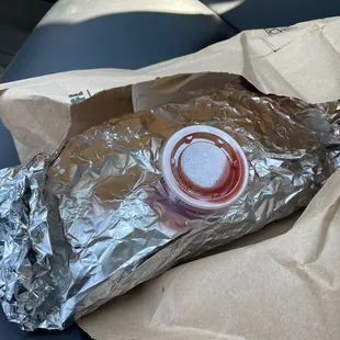 a hot dog wrapped in aluminum foil
