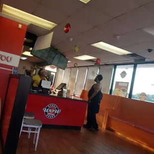 a man standing at a counter in a restaurant