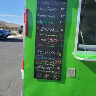 a green food truck with a menu written on it